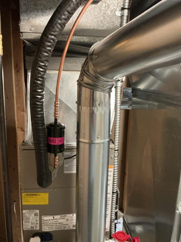 Completed full HVAC system installation in residential basement utility area, including new furnace unit with integrated humidifier system and complete ductwork configuration. Installed metal supply and return ductwork with proper sealing and connections, routed flexible ductwork and conduit lines, and mounted humidifier unit with PVC drainage piping. System placed on drain pan with all components properly connected, labeled, and tested for operational readiness.