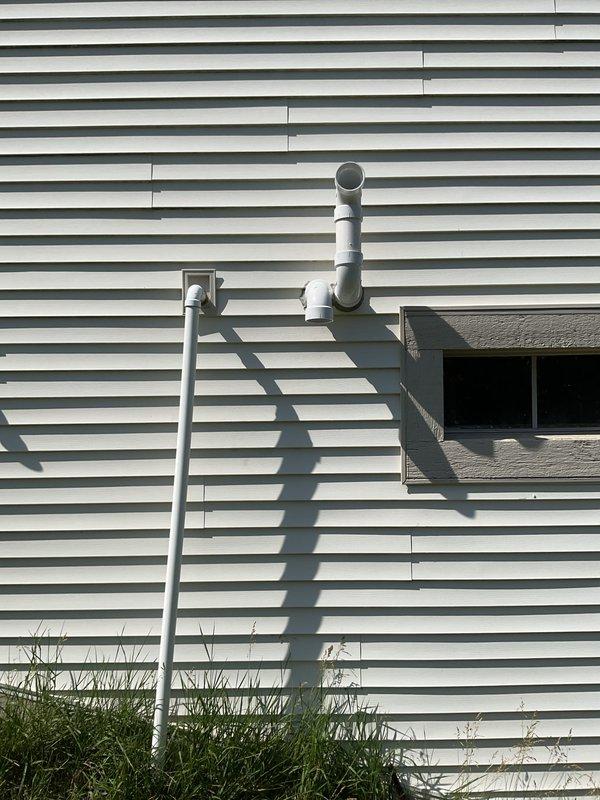 Completed full HVAC system installation including new Bryant condensing unit and furnace with associated venting and refrigerant lines. Unit mounted on wooden platform with proper electrical disconnect, PVC vent piping installed through exterior wall, and all connections tested for proper operation.