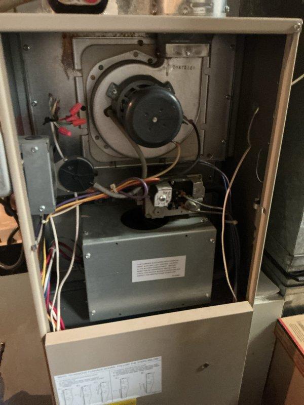 Performed comprehensive gas furnace tune-up and safety inspection on residential forced-air heating system. Removed front access panel to access internal components, inspected blower motor assembly and verified proper operation, checked all electrical connections and wiring throughout cabinet, examined transformer and control box for proper function, and inspected refrigerant lines and ductwork connections. All components found operating within normal parameters and system passed safety inspection.
