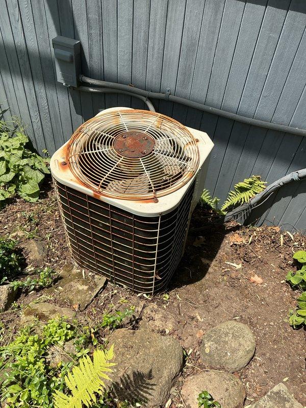 Completed annual air conditioning tune-up and preventive maintenance on 29-year-old outdoor condenser unit. Performed comprehensive system inspection, noting significant rust and corrosion on fan grille, top panel, and hub assembly due to age and weather exposure. Verified proper refrigerant levels, checked electrical connections, cleaned condenser coils, and confirmed operational performance of all components.
