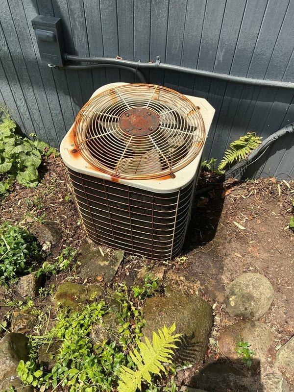 Completed annual air conditioning tune-up and preventive maintenance on 29-year-old outdoor condenser unit. Performed comprehensive system inspection, noting significant rust and corrosion on fan grille, top panel, and hub assembly due to age and weather exposure. Verified proper refrigerant levels, checked electrical connections, cleaned condenser coils, and confirmed operational performance of all components.
