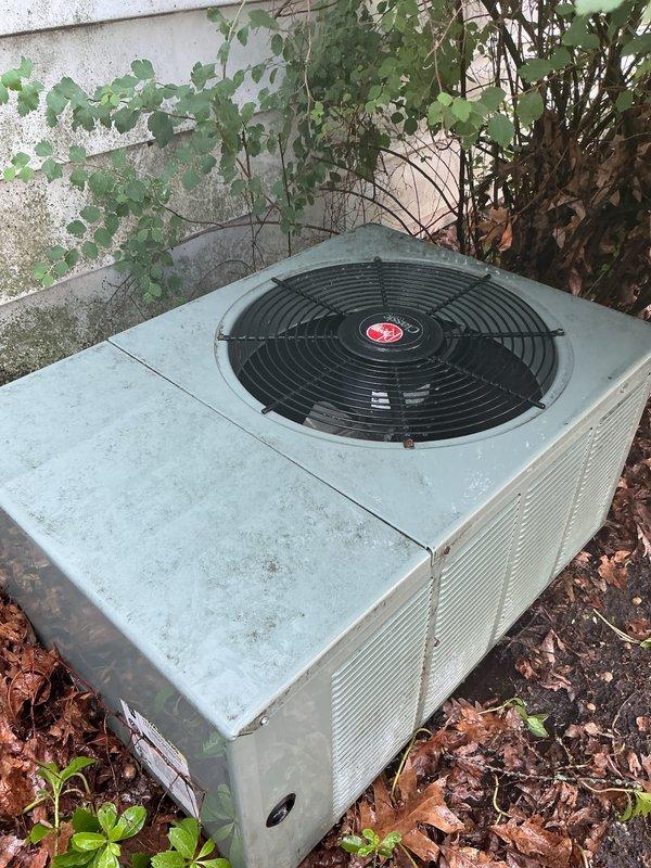 Completed comprehensive tune-up on outdoor AC condenser unit responding to reports of sluggish afternoon cooling performance. Upon arrival, found unit heavily obstructed by overgrown vegetation, accumulated leaves, and debris around base and sides, significantly restricting airflow to condenser coils. Cleared all vegetation from perimeter, removed leaf debris and mulch buildup from base, and cleaned exterior surfaces. Performed standard tune-up procedures including inspection of fan motor operation, electrical connections, refrigerant levels, and coil condition. Advised property management that regular vegetation maintenance around unit is essential for optimal performance and efficiency. Unit operating within normal parameters after service completion.