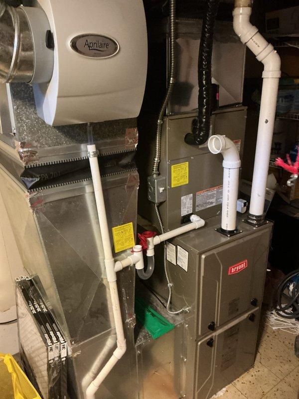 Completed installation of new air conditioning system with evaporator coil in residential basement utility room. System was integrated with existing Bryant furnace and connected to ductwork, with all refrigerant lines, condensate drainage, and electrical connections properly installed and tested for optimal operation.