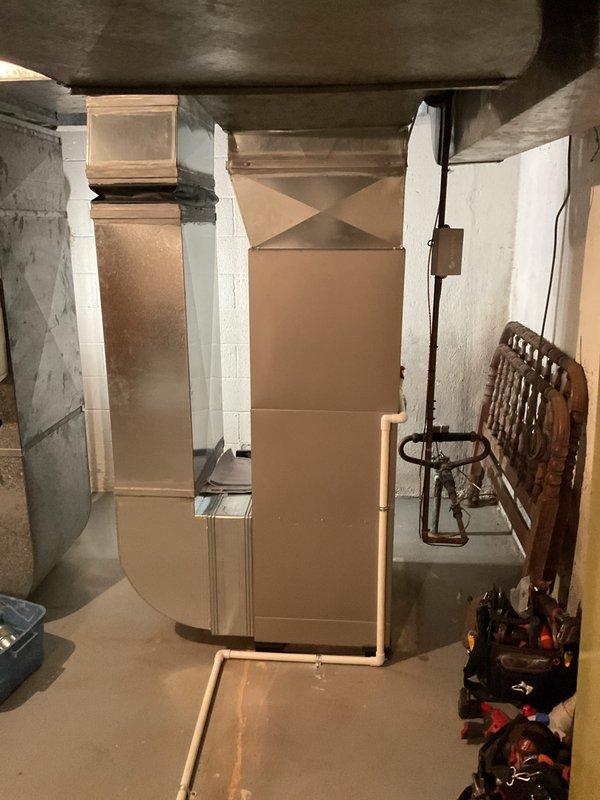 Successfully installed two furnace units and one air conditioning system in basement utility area. First furnace unit mounted on wall with proper electrical connections via black conduit, while second furnace positioned on concrete floor. Both units secured according to manufacturer specifications with all required labels visible and accessible. Connected ductwork to ceiling-mounted distribution system utilizing existing infrastructure. Verified proper clearances from surrounding walls and stored items for safe operation and future maintenance access. Completed all electrical connections, tested system startup sequences, and confirmed operational status of both heating units and cooling system.