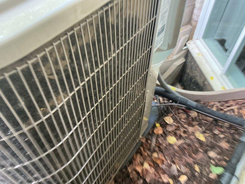 Completed preventive maintenance tune-up on two residential air conditioning systems. Inspected both outdoor condenser units, which showed significant accumulation of leaves, organic debris, and dirt around the bases and on the coil fins. Cleared debris from unit perimeters and cleaned condenser coils to restore proper airflow. Addressed customer concern regarding one unit not cooling to setpoint; performed diagnostic evaluation including temperature differential measurements, refrigerant pressure checks, and thermostat operation verification. Documented equipment conditions with photos showing pre-service debris accumulation. Both systems operational upon completion of service.
