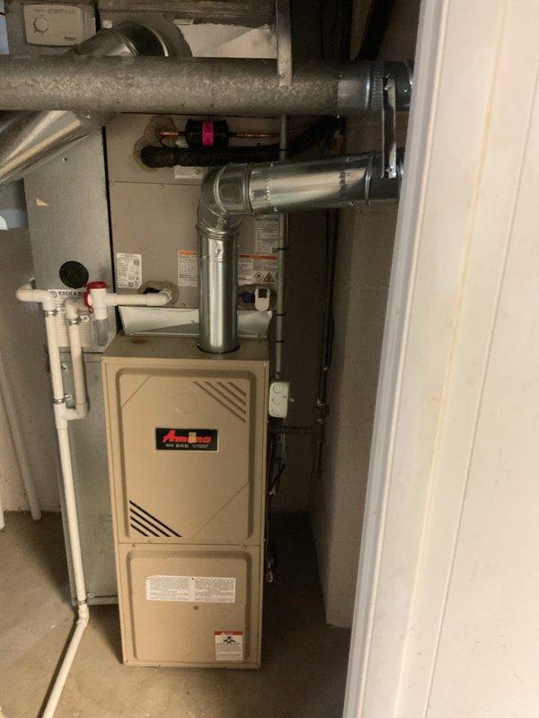 Completed installation of new Bryant air conditioning condenser unit and evaporator coil system. The outdoor condenser was positioned on a concrete pad in the side yard with proper electrical disconnect and conduit connections to the brick exterior. Inside the basement utility area, installed new evaporator coil on existing furnace unit with appropriate refrigerant line connections and condensate drainage integrated into existing PVC plumbing system. System was tested and verified operational upon completion.