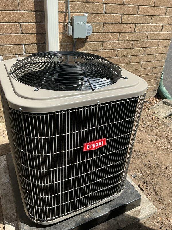 Completed full HVAC system installation including new Bryant air conditioning condenser unit and furnace with associated PVC venting. The outdoor condenser was positioned on a concrete pad against the building exterior with proper electrical disconnect installed, while the indoor furnace installation included dual white PVC vent pipes routed through the mechanical space for intake and exhaust functions. All components were installed to manufacturer specifications with proper mounting, drainage, and ventilation to ensure optimal system performance and code compliance.
