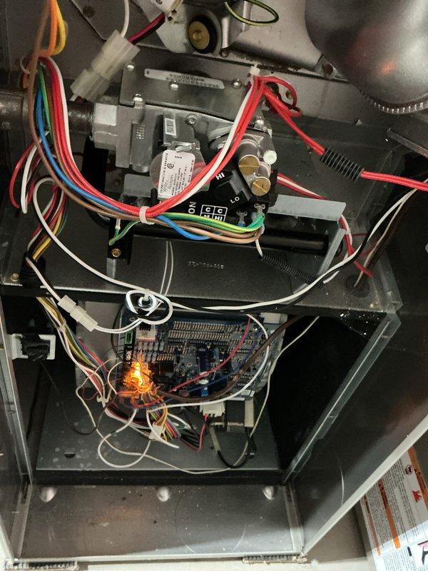 Completed comprehensive furnace and air conditioning tune-up maintenance service on residential HVAC system. Performed thorough inspection of all interior components including gas valve assembly, control board, electrical connections, blower assembly, and safety systems. Verified proper operation of ignition system with flame sensor showing active illumination, confirmed all wire connections and harnesses were secure with appropriate color-coding intact, and documented system condition through photographic records. All components found operating within normal parameters with no immediate repairs required.