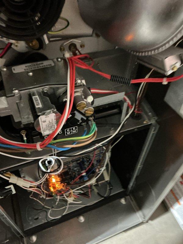 Completed comprehensive furnace and air conditioning tune-up maintenance service on residential HVAC system. Performed thorough inspection of all interior components including gas valve assembly, control board, electrical connections, blower assembly, and safety systems. Verified proper operation of ignition system with flame sensor showing active illumination, confirmed all wire connections and harnesses were secure with appropriate color-coding intact, and documented system condition through photographic records. All components found operating within normal parameters with no immediate repairs required.