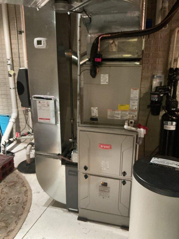 Completed full HVAC system installation including Bryant furnace in basement utility room and matching Bryant condenser unit on exterior pad. Installed new copper refrigerant lines with insulation connecting outdoor condenser to indoor evaporator coil, routed electrical disconnect and conduit to outdoor unit mounted on house exterior, and positioned condenser on composite pad over gravel base for proper drainage and vibration isolation. All equipment tested and verified operational with manufacturer specifications confirmed.