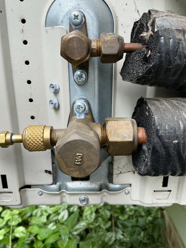 Responded to service call for 3-year-old Daikin mini split system with complete loss of heating and cooling function. Upon inspection, accessed outdoor unit service ports and refrigerant line connections. Documented condition of brass service valves, compression fittings, and insulated refrigerant lines at connection panel. System components showed normal aging with minor surface oxidation on brass fittings but no visible refrigerant leaks or damaged insulation at inspection points.
