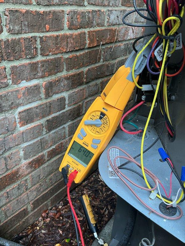 Completed comprehensive AC tune-up on residential condensing unit with electrical diagnostics and system performance verification. Performed voltage testing using digital multimeter, confirming proper electrical supply at 60.1V to outdoor unit. Inspected all electrical connections, capacitor operation, and refrigerant line integrity at outdoor condenser. Evaluated airflow concerns throughout home, specifically addressing reported cooling deficiency in upstairs northwest corner bathroom. System operational following preventive maintenance inspection.