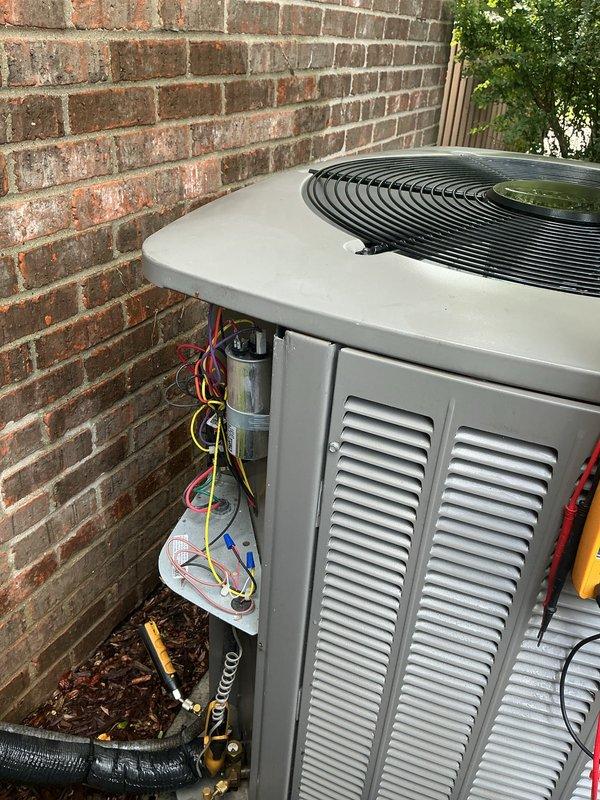 Completed comprehensive AC tune-up on residential condensing unit with electrical diagnostics and system performance verification. Performed voltage testing using digital multimeter, confirming proper electrical supply at 60.1V to outdoor unit. Inspected all electrical connections, capacitor operation, and refrigerant line integrity at outdoor condenser. Evaluated airflow concerns throughout home, specifically addressing reported cooling deficiency in upstairs northwest corner bathroom. System operational following preventive maintenance inspection.