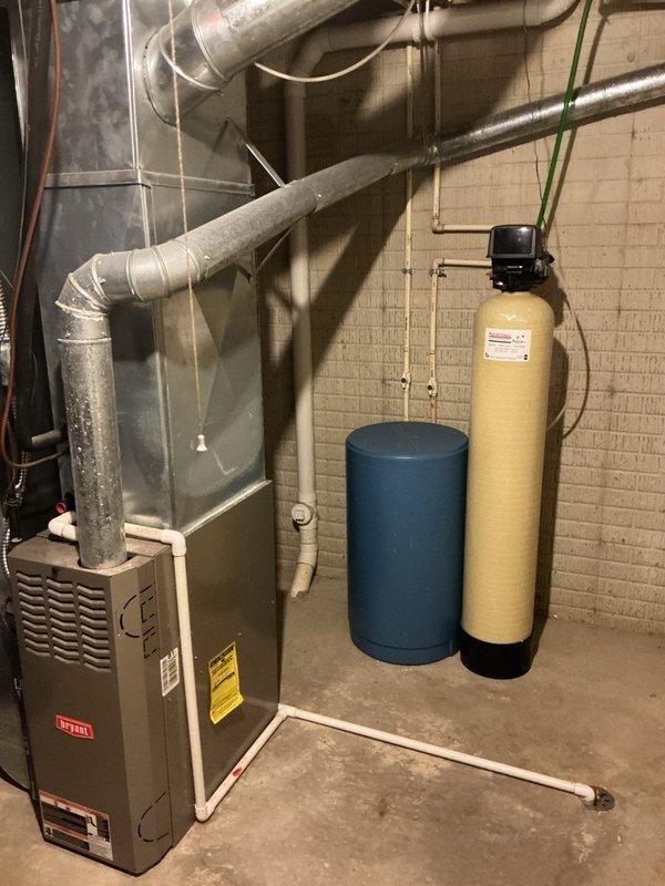 Responded to no-cooling call on older Bryant system. Found outdoor condenser fan motor inoperative while indoor air handler continued to run. Inspected outdoor unit and confirmed fan motor failure, likely due to age and wear on existing equipment. Tested capacitor and electrical connections at condensing unit. Provided system assessment and replacement options for aging HVAC system as requested. Documented equipment condition with photos of basement installation including furnace, ductwork, and associated mechanical components.