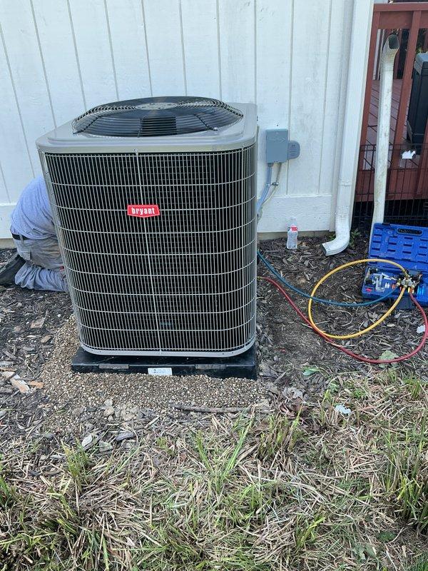 Completed full HVAC system installation including furnace, air conditioner, and humidifier at residential property. New outdoor condensing unit was positioned on equipment pad against building exterior with proper clearances maintained. All refrigerant lines were connected and system was charged to manufacturer specifications. Electrical disconnect installed and wired per code requirements. Interior furnace and humidifier components were integrated into existing ductwork. System was tested for proper operation, airflow verified, and all safety controls checked for functionality.