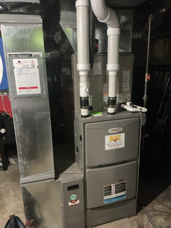 Completed installation of new Lennox HVAC system including air conditioning unit and evaporator coil. Installed furnace in basement utility area with proper venting using white PVC condensate drain lines and elbows. Connected electrical service disconnect box and integrated black flexible ductwork to system. Routed exterior PVC drainage line through foundation with appropriate weatherproofing and sealing. All components installed to manufacturer specifications and tested for proper operation.