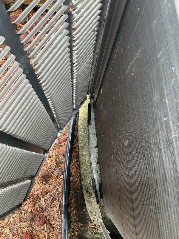 Performed comprehensive annual air conditioning tune-up and preventative maintenance on outdoor condenser unit. Accessed unit and discovered heavily soiled air filter and significant debris accumulation (leaves, twigs, pine needles, and organic matter) in coil channels and between heat exchanger fins. Cleaned condenser coils, removed all debris from unit interior and gaps, and replaced dirty filter to restore proper airflow and system efficiency.