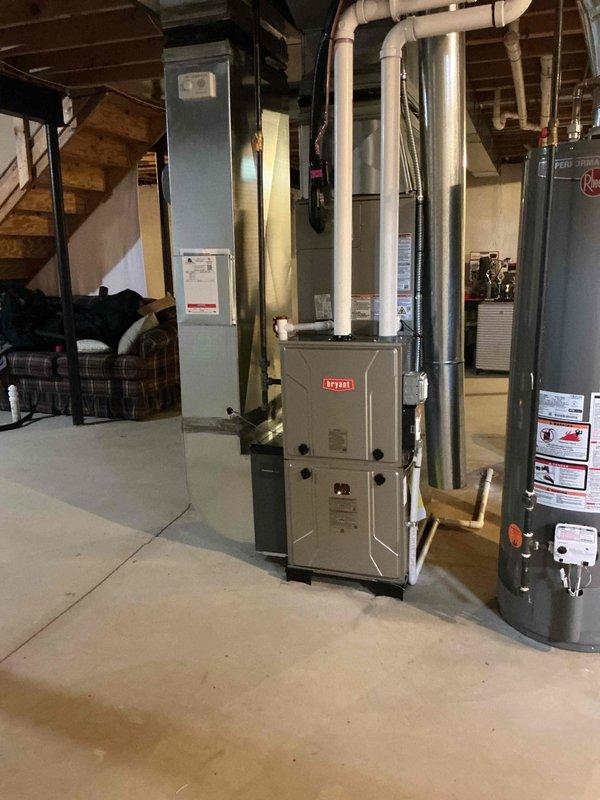 # HVAC Complete System Installation

Successfully completed a full HVAC system installation in residential basement, including a new Bryant furnace, air conditioning system, humidifier, and air purification unit. All equipment was professionally mounted with proper clearances, connected to newly routed galvanized metal ductwork extending through ceiling joists, and integrated with existing infrastructure. System was tested for proper operation, airflow distribution verified, and all safety specifications confirmed to meet manufacturer requirements and code compliance.