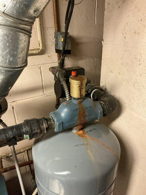 Responded to reported boiler leak in basement utility area. Upon arrival, performed thorough inspection of boiler system, pressure regulator assembly, expansion tank, and associated piping connections. Identified source of leak at valve assembly connected to expansion tank. Tightened fittings at brass valve connections and pressure relief valve. Inspected copper supply lines, black iron piping, and flexible hose connections for additional leak points. Verified proper operation of pressure regulator and gauge readings. Documented existing conditions of expansion tank and valve assembly with photographic evidence. System tested and confirmed no active leaking upon completion of repairs.