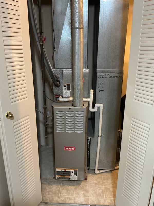 Responded to service call for AC unit freezing and inadequate cooling. Upon arrival, found evidence of excessive condensation in mechanical closet with visible moisture on floor around air handler and furnace area. Inspected Bryant furnace system and associated ductwork, noting rust streaking on galvanized ductwork indicating prolonged moisture exposure. Evaluated evaporator coil freezing condition and identified restricted airflow as primary cause. Checked refrigerant levels, airflow patterns, and drainage system. Cleared condensate drain line blockage causing water backup. System returned to normal operation with proper cooling restored.