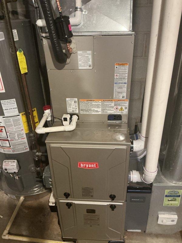 Completed full HVAC system installation including new Bryant furnace and air conditioning unit in residential basement utility area. Installation included proper refrigerant line connections, PVC condensate drainage piping, gas supply line configuration with shutoff valves, and integration with existing water heater system. All equipment mounted to manufacturer specifications with appropriate clearances, electrical connections completed per code requirements, and system tested for proper operation upon startup.
