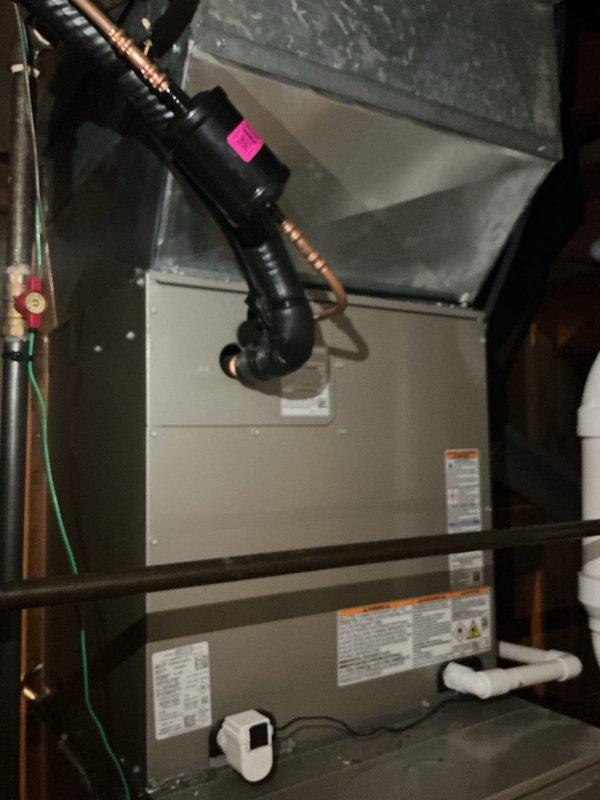 Completed full HVAC system installation including new furnace, air conditioning unit, and whole-home humidifier. Installed air handler unit in attic mechanical space with evaporator coil, refrigerant line set, and associated ductwork connections. Mounted condensate pump with drainage piping routed to building exterior through PVC discharge system. All equipment properly labeled, secured to platform mounting, and tested for operational performance.