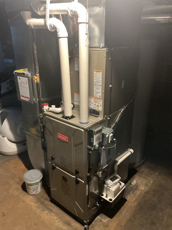 Completed full HVAC system installation in residential basement utility area, including new Bryant furnace, air conditioning system, and whole-home humidifier. Installed furnace with proper PVC venting configuration utilizing 90-degree elbows for exhaust routing, established all necessary gas line connections, and integrated condensate drain lines. Mounted and connected air handler unit, verified all electrical connections including conduit routing, and ensured proper ductwork integration with existing infrastructure. All equipment labeled with manufacturer specifications and safety warnings, system tested and operational upon completion.