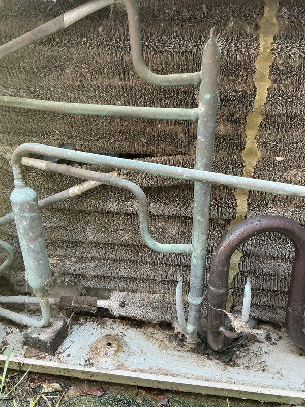 Completed comprehensive AC tune-up and system evaluation on residential HVAC unit. Performed standard maintenance protocol including inspection of evaporator coil assembly, refrigerant lines, and associated components. Observed significant aging and corrosion on copper refrigerant piping with white oxidation buildup and deterioration of foam insulation on multiple line sets. Documented heavy dust and debris accumulation on aluminum evaporator fins requiring attention. Noted bare copper U-bend section showing advanced patina and oxidation, along with moisture damage indicators on insulated lines. System operational at time of service; collected renewal payment and scheduled follow-up appointment.