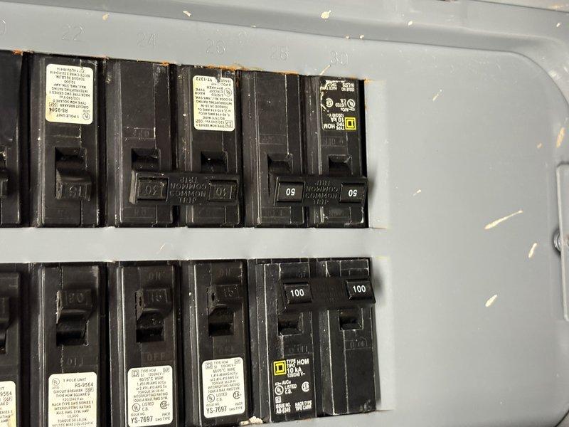Responded to no-cooling call with thermostat displaying no power and water present on floor near air handler. Diagnosed tripped circuit breaker due to clogged condensate drain line causing secondary overflow switch activation. Cleared condensate line blockage, reset breaker in electrical panel, and verified system operation with proper cooling restored and thermostat powered on.