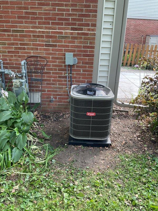 Completed installation of new air conditioning system including outdoor condensing unit and indoor evaporator coil. The outdoor unit was positioned on a protective pad against the building's exterior with proper clearances maintained for optimal airflow and service access. All refrigerant lines were properly connected and insulated, electrical connections were made to code specifications, and the condensate drainage system was installed and tested for proper operation. The indoor evaporator coil was integrated with the existing furnace system in the utility room, with all ductwork connections sealed and secured. System was charged with refrigerant to manufacturer specifications, startup procedures were completed, and full operational testing confirmed proper cooling performance and temperature differentials across the coil.