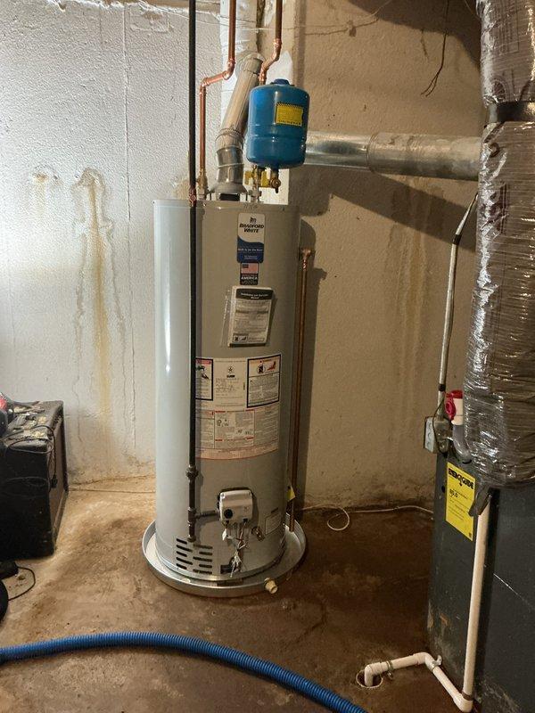 Completed installation of new water heater in basement utility room with proper expansion tank and copper supply line connections. Installed associated PVC drainage and venting system with multiple fittings to ensure proper code compliance and safe operation. All plumbing connections were tested and verified for proper function prior to completion.