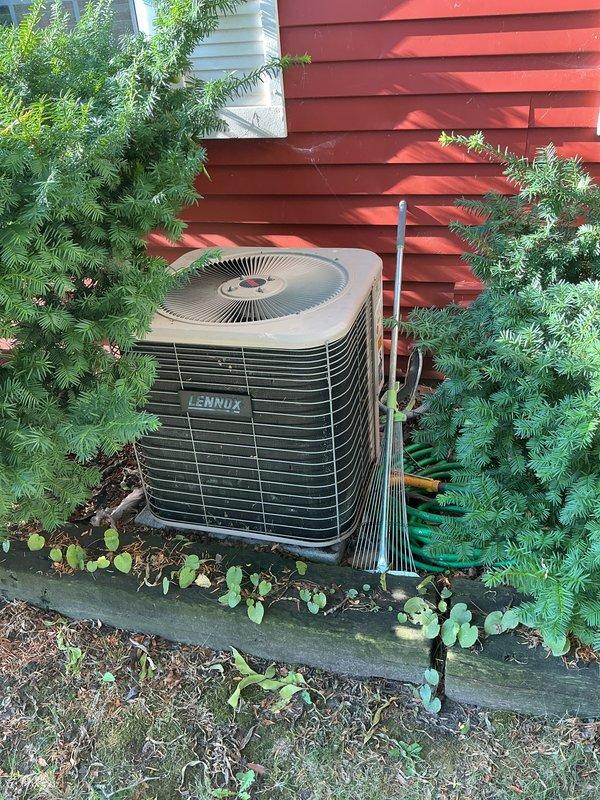 Performed comprehensive air conditioning tune-up on Lennox outdoor condensing unit as included maintenance with recent gas furnace installation. Completed full system inspection, recorded equipment model and serial number information from manufacturer data plate, verified proper operation of condenser fan motor and compressor, and documented unit condition with photographs showing installation location against building exterior with adequate clearance from surrounding vegetation.