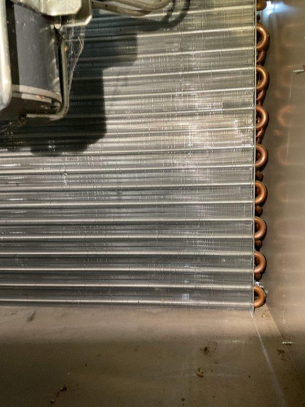 Performed comprehensive AC tune-up on residential HVAC system. Inspected evaporator coil assembly and heat exchanger, verified aluminum fins were clean and properly spaced, checked refrigerant line connections and copper tubing for proper condition, and documented system components with photos. All components found to be in good working order with no immediate service needs identified.