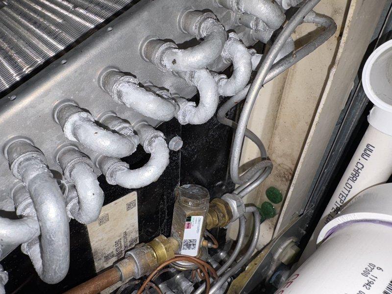 Responded to no-cooling call following recent duct cleaning work. Upon arrival, found evaporator coil completely frozen with heavy ice buildup on refrigerant lines and suction line set. System had been cycling on and off since duct work was completed. Shut down system to allow coil to thaw completely. Identified restricted airflow as root cause—discovered return air filter was either missing or extremely dirty following duct cleaning, causing insufficient airflow across evaporator coil and subsequent freezing. Once thawed, verified proper airflow through system, checked filter installation, and confirmed all ductwork connections were secure and not restricting airflow. Restarted system and monitored operation through complete cooling cycle. Verified proper refrigerant pressures, temperature split, and system operation. Unit restored to normal cooling operation.