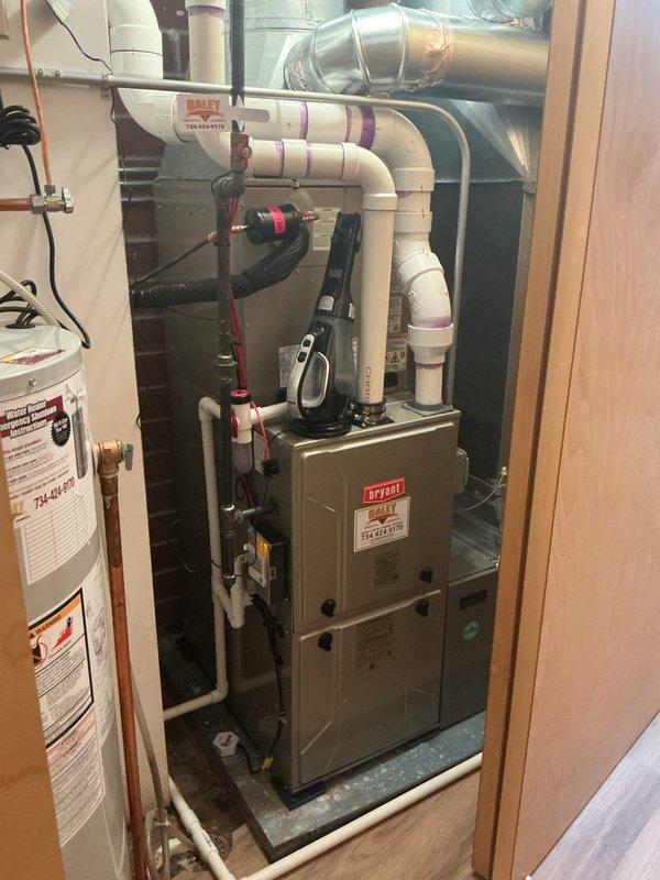 Completed full HVAC system installation in residential mechanical room, including new Bryant furnace unit mounted on concrete pad with proper venting configuration utilizing white PVC piping system. Installed and integrated complete air distribution ductwork with metallic supply and return runs, coordinated plumbing connections including copper piping, and established all electrical connections with proper conduit routing and outlet configuration to ensure code-compliant operation of heating and cooling equipment.