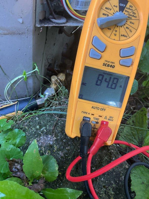 Responded to cooling system service call and performed diagnostic testing on outdoor condensing unit. Accessed internal electrical components, utilized digital multimeter to measure voltage and verify proper electrical operation, confirmed system readings within normal parameters at 898 reading during testing. Completed electrical diagnostics, reassembled unit, and restored system to normal cooling operation.