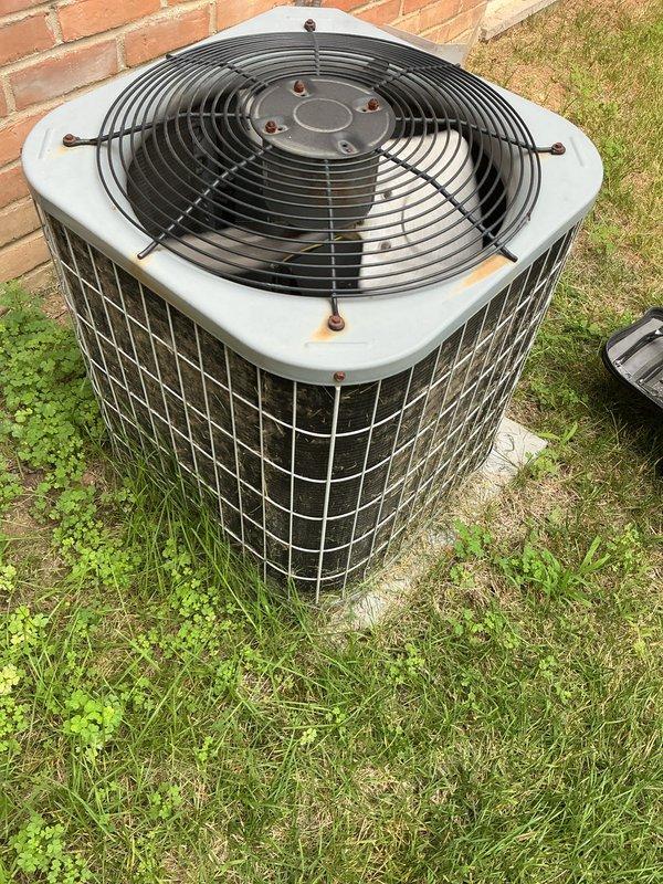 Completed comprehensive air conditioning tune-up on residential outdoor condenser unit. Performed full system inspection, cleaned condenser coils, checked refrigerant levels, tested electrical connections, and verified proper fan motor operation. Unit showed normal wear with surface rust on top panel but all components functioning within manufacturer specifications. System running efficiently with no immediate service needs identified.