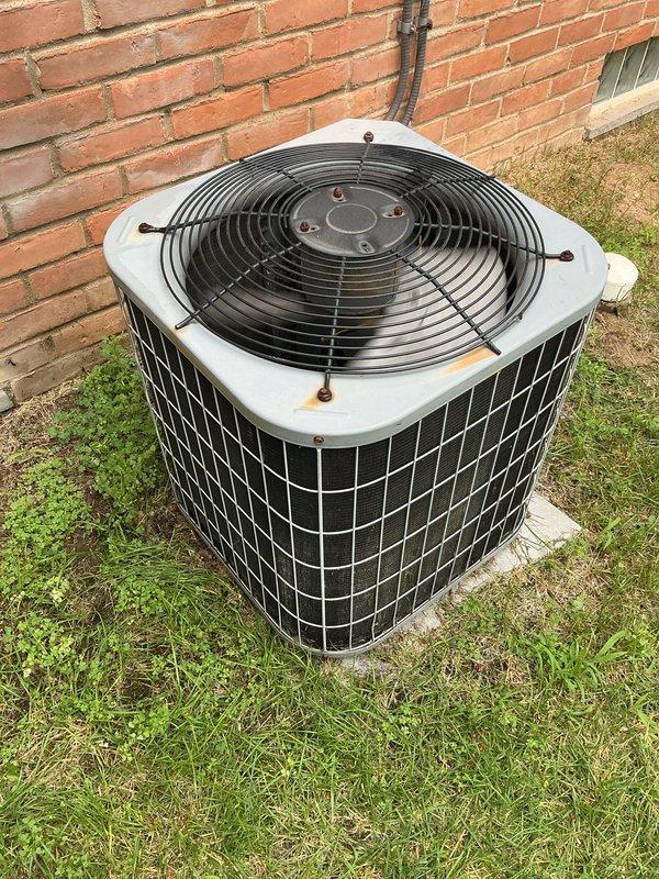 Completed comprehensive air conditioning tune-up on residential outdoor condenser unit. Performed full system inspection, cleaned condenser coils, checked refrigerant levels, tested electrical connections, and verified proper fan motor operation. Unit showed normal wear with surface rust on top panel but all components functioning within manufacturer specifications. System running efficiently with no immediate service needs identified.