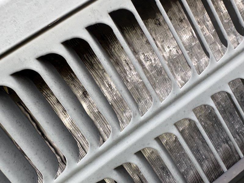 Responded to no cooling complaint on residential air conditioning system. Upon inspection, found evaporator coil heavily contaminated with dust and debris buildup, significantly restricting airflow through the unit. Return air grate also showed substantial dust accumulation. Cleaned evaporator coil fins and cleared blockages to restore proper airflow and system operation. Unit tested and confirmed blowing cold air upon completion.