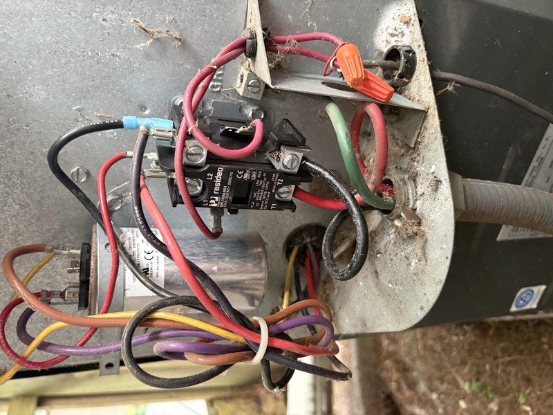 # HVAC Service Call - No Cool Condition

Responded to a no cooling complaint on a commercial HVAC unit. Upon arrival, conducted visual inspection of the outdoor condensing unit and electrical control components. Found evidence of significant weathering and environmental exposure on the equipment exterior and control assembly.

Performed electrical diagnostics on the contactor and relay assembly. Identified a failed contactor with visible signs of deterioration, including corroded brass terminals, oxidized contact points, and accumulated carbon deposits on the contact surfaces. The component showed extensive wear from prolonged service, with tarnished terminals and darkened connection points indicating electrical arcing and poor contact integrity.

Removed the defective contactor from the control panel assembly. Inspected associated wiring connections, including multiple control circuits identified by red, black, orange, yellow, purple, green, and blue conductors. Verified wire terminat