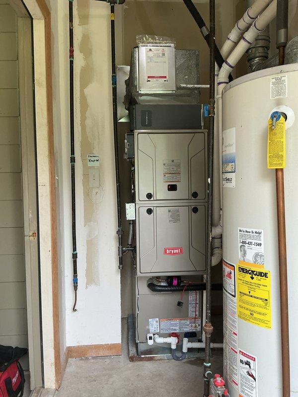 Completed full HVAC system installation including a new Bryant furnace in the utility room and Trane condensing unit positioned outdoors on a concrete pad. The indoor furnace was properly mounted with connecting ductwork and ventilation components, while the outdoor unit was set on a level concrete base with appropriate clearances from the structure. All refrigerant lines, electrical connections, and drainage piping were installed to manufacturer specifications, and both heating and cooling systems were tested for proper operation upon completion.