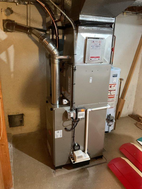 Completed full HVAC system installation in basement utility area, including new furnace and air conditioning unit with proper venting and ductwork connections. Installed metal exhaust flue piping, connected electrical components and control panels, and routed copper refrigerant lines according to manufacturer specifications. All equipment tested and verified operational with proper airflow and temperature output.