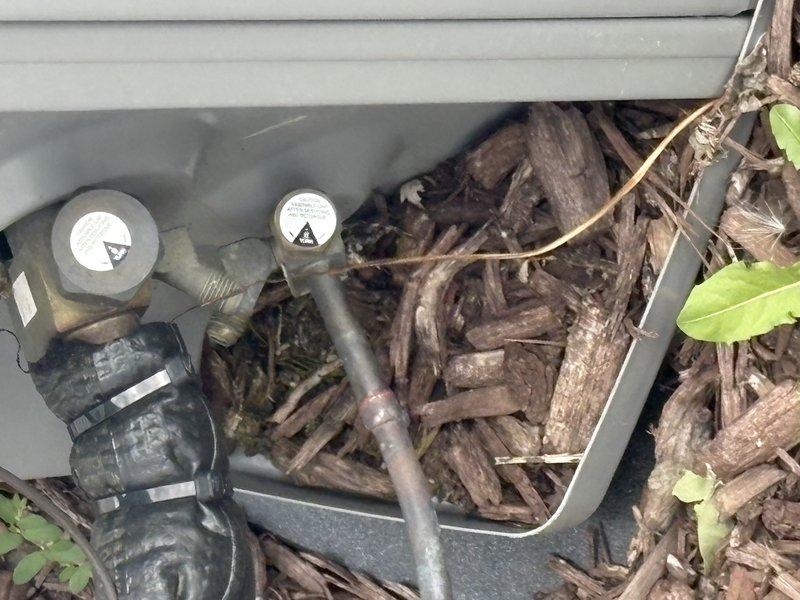 Responded to service call for water accumulation on floor beneath furnace unit. Upon arrival, performed comprehensive system inspection of indoor HVAC components. Examined evaporator coil assembly and surrounding insulated enclosure for signs of condensate drainage issues or refrigerant leaks. Inspected condensate drain line routing from air handler, checking for blockages, improper pitch, or disconnected drain components. Verified condensate pump operation if applicable. Checked evaporator coil fins for frost accumulation or excessive condensation that could indicate airflow restrictions or refrigerant charge problems. Examined exterior utility connections and ground-level service area near building foundation. Assessed condition of refrigerant lines, electrical connections, and control components within air handler cabinet. Documented equipment condition through photographic evidence showing evaporator coil, foil-faced insulation installation, copper refrigerant lines, and exterior u