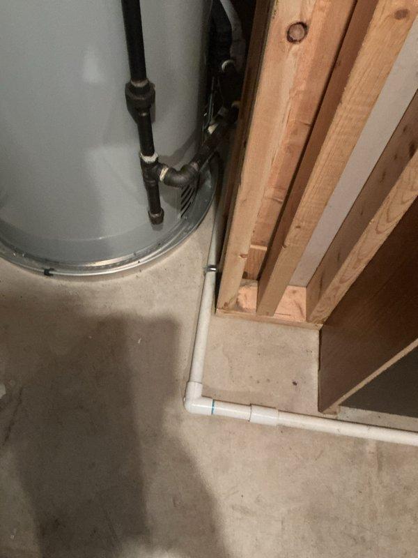 Completed HVAC system installation with proper exterior PVC venting configuration installed through building foundation and extending vertically along exterior wall. New water heater installed in basement utility area with appropriate black flex connector piping and secure metal clamp connections. Follow-up visit scheduled to address remaining punch list items to finalize installation warranty work.