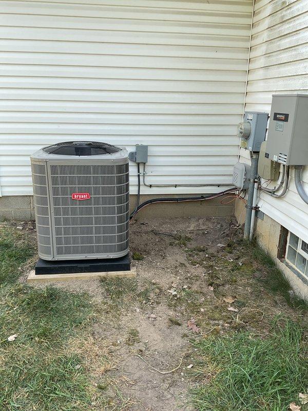 Completed installation of Bryant air conditioning system including outdoor condenser unit and indoor evaporator coil. Outdoor unit was positioned on rubber isolation pad adjacent to home exterior with proper clearances maintained, electrical disconnect and line set connections established per manufacturer specifications. Indoor evaporator coil was integrated with existing furnace system in basement mechanical room, with refrigerant lines and condensate drainage properly installed. All electrical connections, refrigerant charging, and system startup procedures were completed and verified for proper operation.