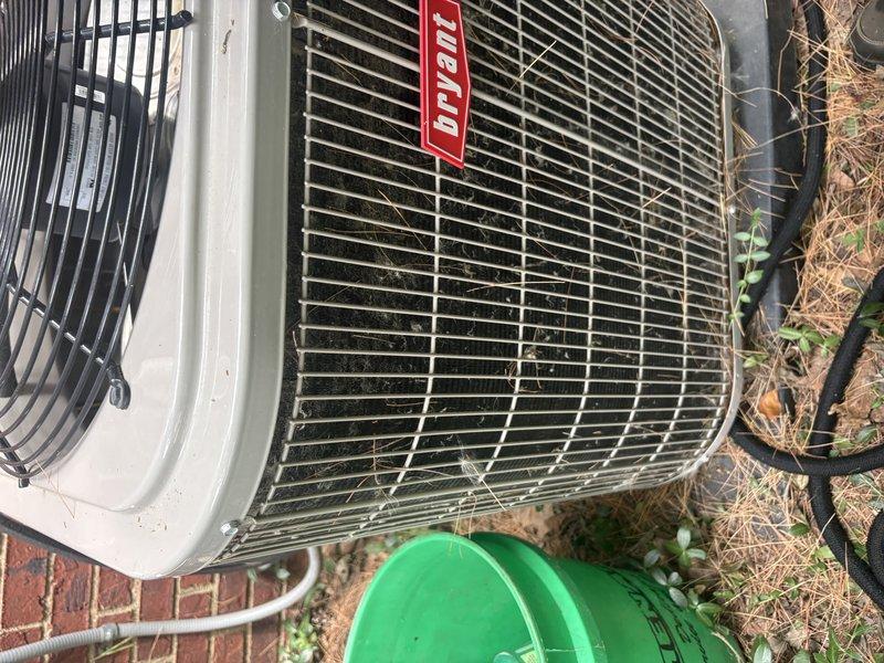 Responded to service call for Bryant air conditioning unit reported to be operating improperly with suspected low refrigerant charge. Upon arrival, performed visual inspection of outdoor condensing unit and documented equipment condition with photographs. Unit appeared operational with accessible condenser coils visible through top grille, though surrounding area showed minimal maintenance with vegetation growth near base. Completed diagnostic assessment of system performance and refrigerant levels to determine necessary repairs.