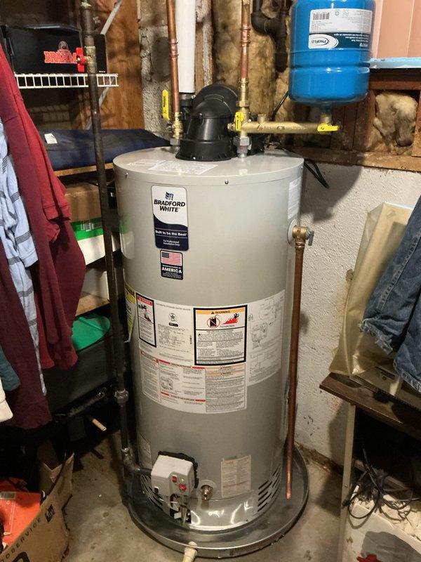Installed new Bradford White gas-fired tanked water heater in basement utility area. Connected copper supply and outlet piping to unit, integrated existing plumbing infrastructure including pressure tank and circulation pump system. Verified all gas connections, water connections, temperature and pressure relief valve operation, and proper venting per manufacturer specifications and local code requirements.