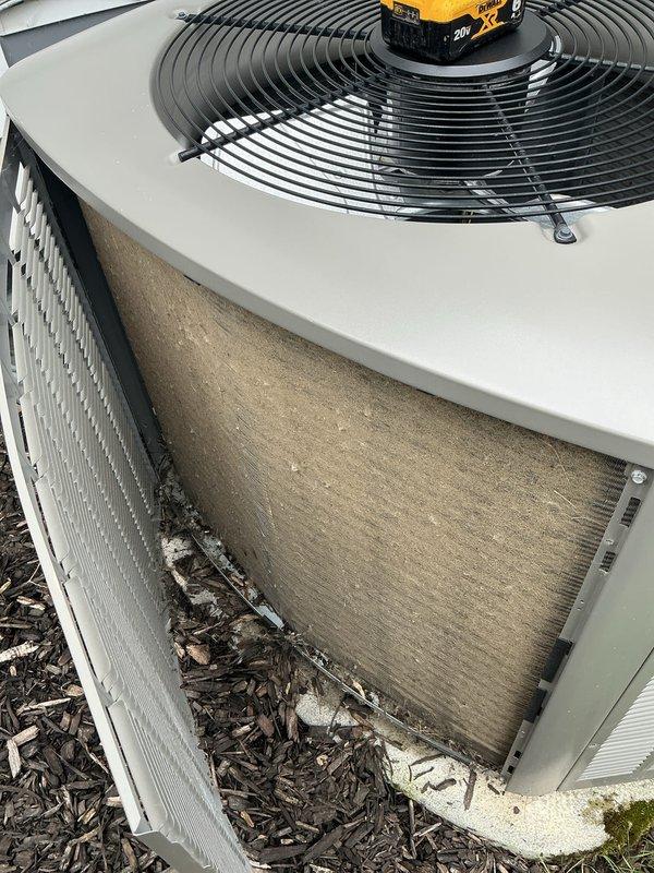 Performed comprehensive air conditioning tune-up on outdoor condensing unit. Upon arrival, noted significant dirt and debris accumulation on condenser coil and internal components visible through side ventilation panels. Completed full system inspection, cleaned condenser coils, checked refrigerant pressures, tested electrical components, verified proper fan operation, and ensured unit was operating within manufacturer specifications. System restored to optimal cooling performance with improved airflow efficiency following maintenance procedures.