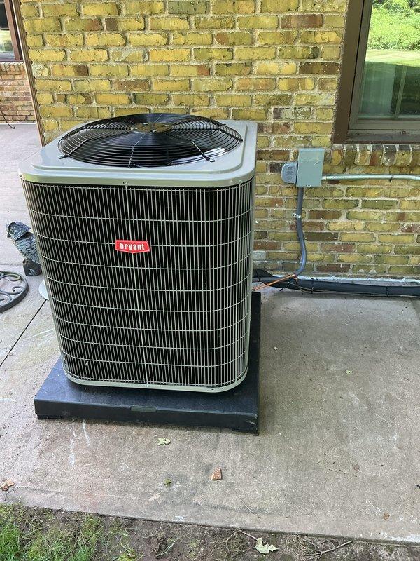 Completed full HVAC system installation including Bryant furnace in basement utility space and matching Bryant condenser unit on exterior concrete pad. Furnace installation included proper PVC venting configuration with multiple elbows for exhaust and intake, metallic supply ductwork connection, humidifier integration, and electrical panel wiring. Exterior condenser positioned on mounting pad against brick wall with gray PVC refrigerant line set properly secured to building with mounting brackets and electrical disconnect box installed per code requirements. All equipment tested and operational upon completion.