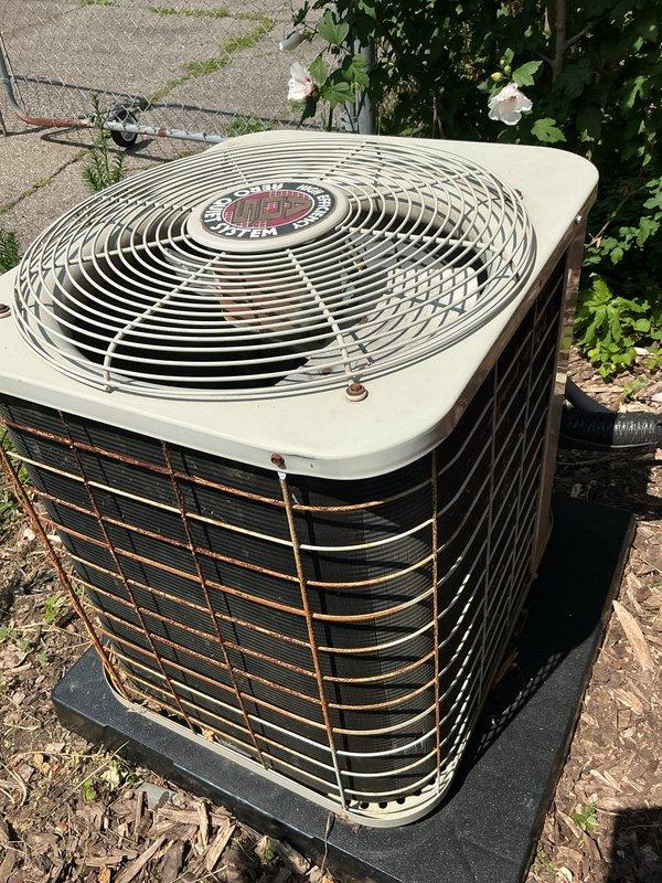 Completed comprehensive air conditioning tune-up on outdoor condensing unit. Performed standard preventive maintenance inspection including checking refrigerant levels, cleaning condenser coils, testing electrical connections at disconnect box, verifying proper fan operation, and inspecting overall unit condition. Unit showed signs of age with rust formation on exterior louvers and grilles, but all mechanical components functioned within normal operating parameters upon completion of service.